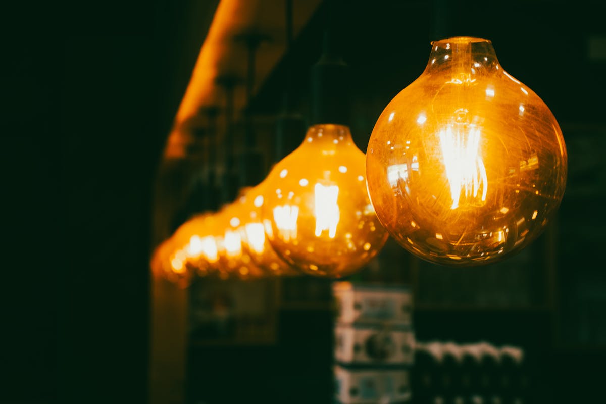 Light bulbs emitting light energy in a dim room — an everyday example