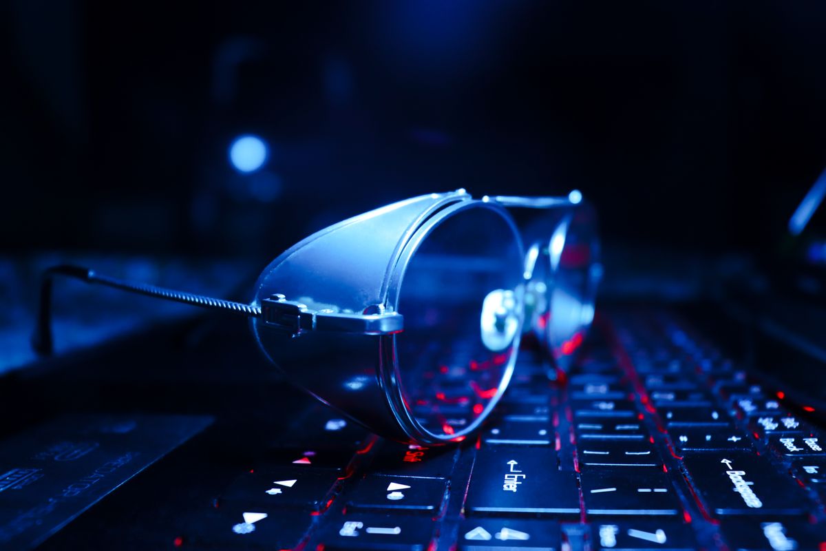 Glasses resting on a glowing laptop, illustrating how blue light glasses work
