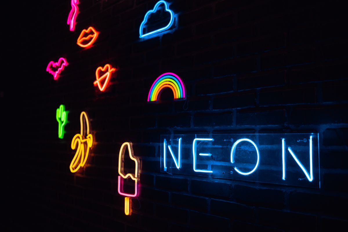 Glowing neon signs, light emitted as electrons drop between energy levels