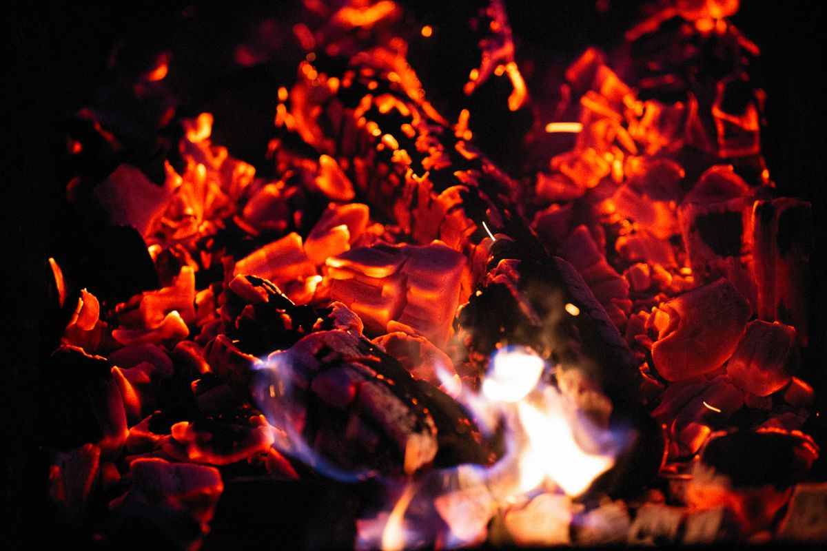 Glowing embers radiating infrared, a type of light you feel as heat